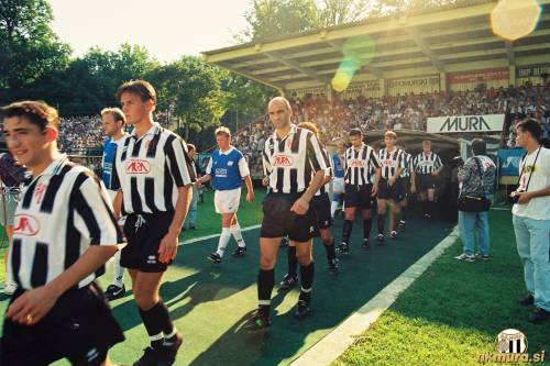 Prihod igralcev Mure in Lyngbyja na igrišče. Muraši od leve: Vladimir Kokol, Simon Dvoršak, Marijan Bakula, Nebojša Vučičević (skrit za Bakulo), Alen Ščulac, Štefan Škaper, Danijel Brezič in Franc Cifer. Skrajno desno je fotograf Aleš Cipot.